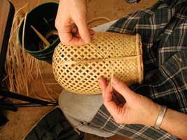 Closeup of Judy Zugish's hands working on a basket